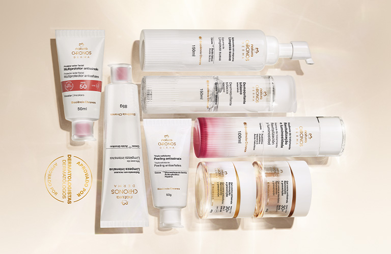 Banner de productos de la línea Chronos sobre un fondo beige claro. Frascos, botes y tubos blancos dispuestos artísticamente.